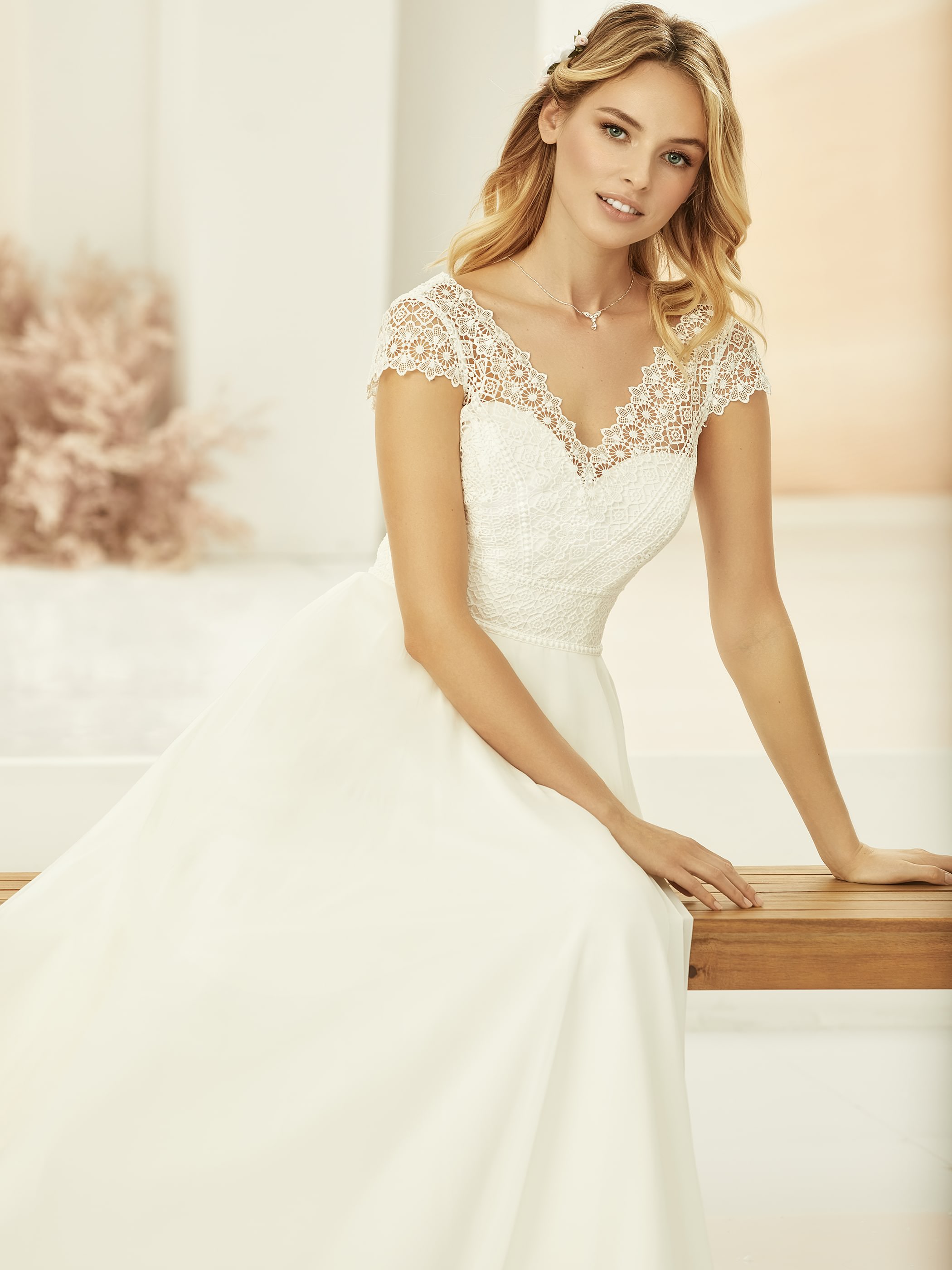 Vintage Brautkleid ist aus Spitze gefertigt und mit einem herzförmigen Ausschnitt. Brautmoden Outlet Köln